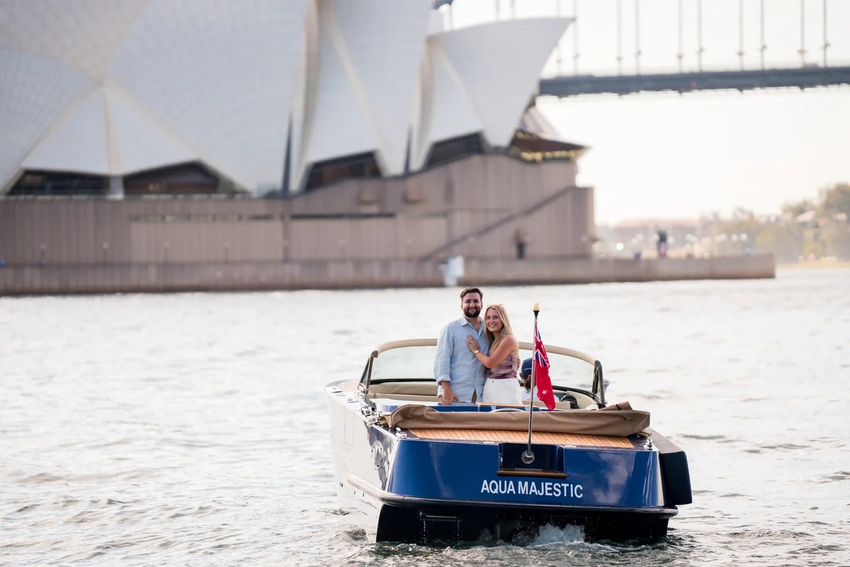 Chelsea and Alex celebrating their engagement on Sydney Harbour